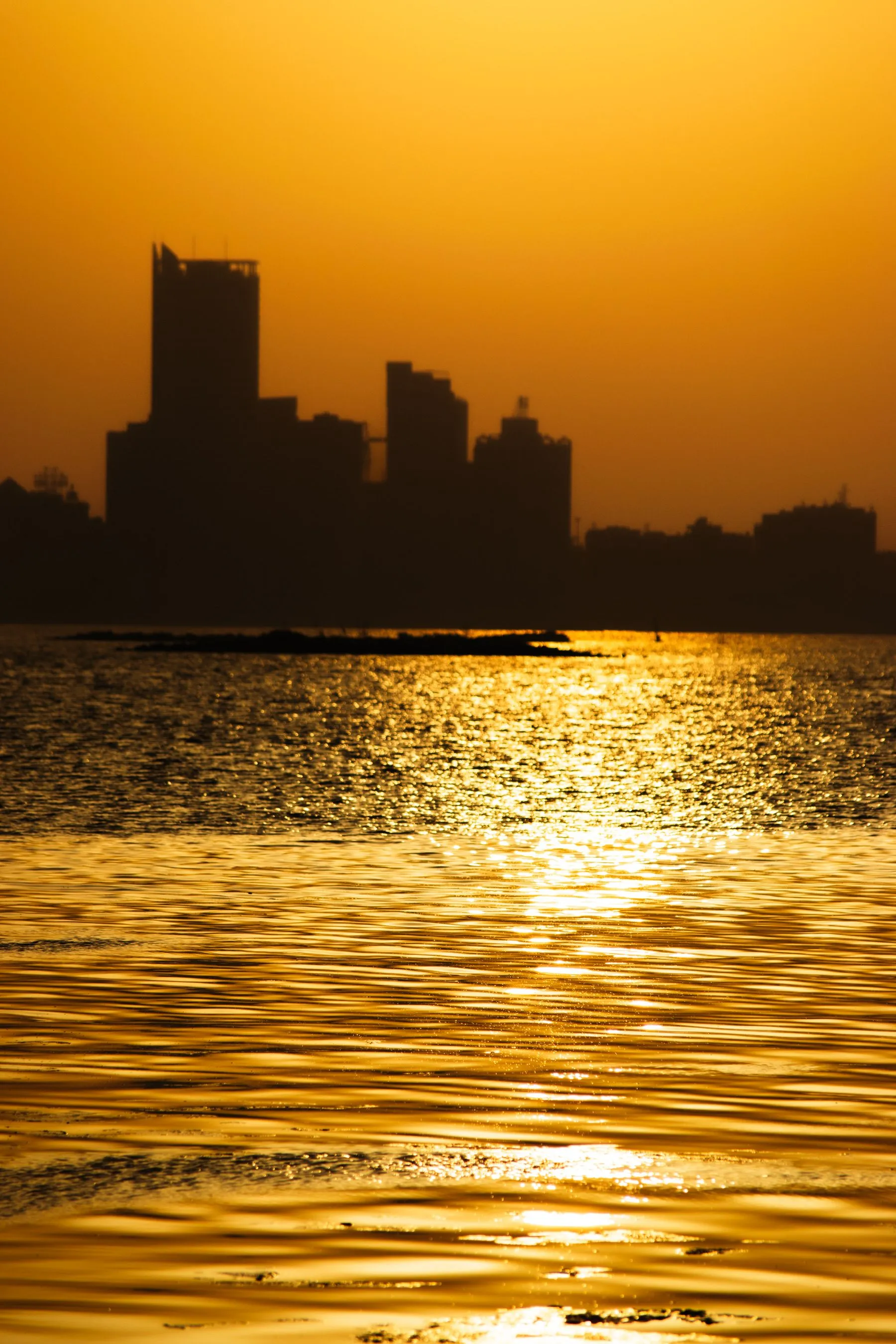 Manama sziluettje naplementekor a tenger felől, Bahrein